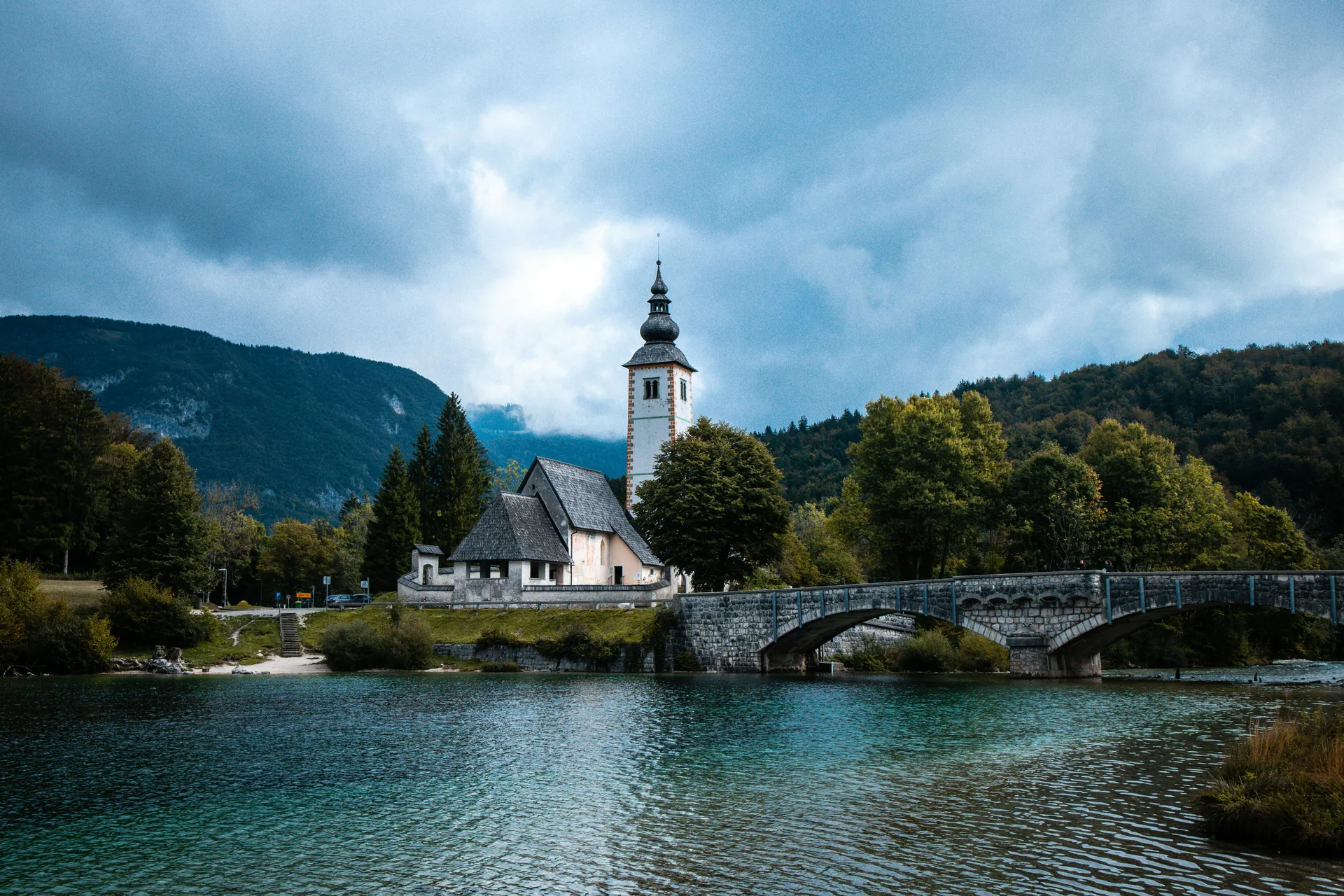 Picturesque view of St. John the Baptist Church and bridge over Lake Bohinj in Slovenia.